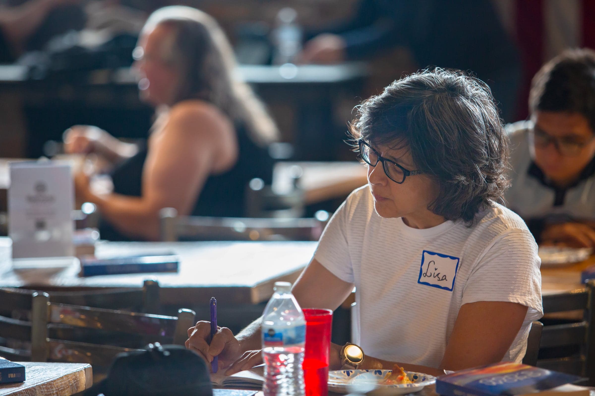 A woman taking notes at a table during a church gathering